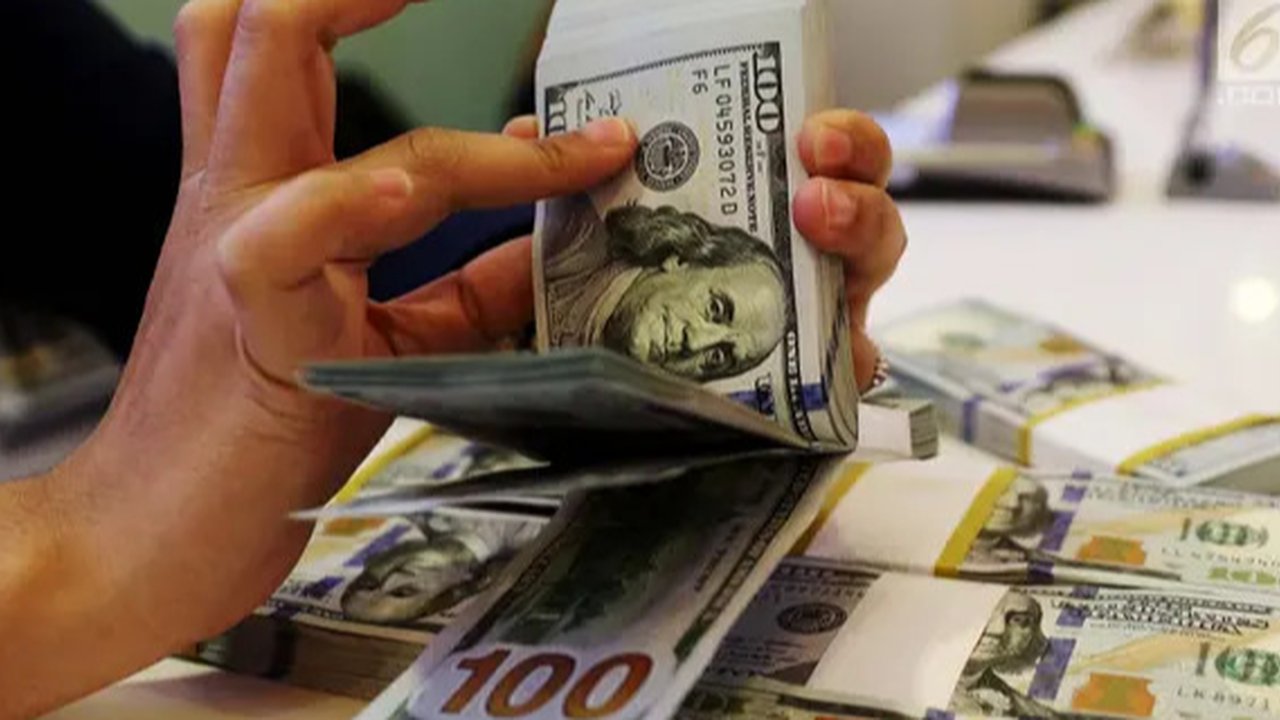 Karyawan menunjukkan uang dolar AS dan rupiah di Jakarta, Rabu (30/12/2020). Nilai tukar rupiah di pasar spot ditutup menguat 80 poin atau 0,57 persen ke level Rp 14.050 per dolar AS. (Liputa