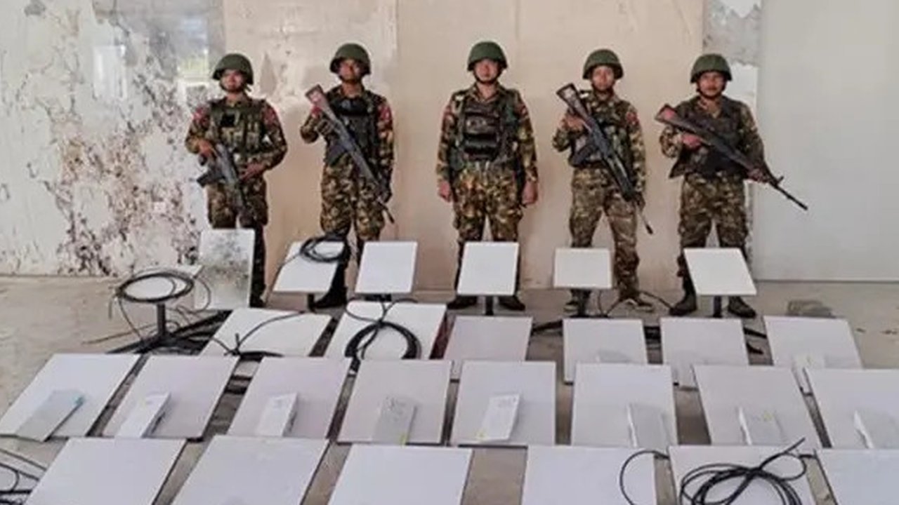 Dalam foto yang dirilis oleh militer Myanmar pada 19 Oktober 2025, tampak para tentara berdiri di samping perangkat Starlink saat melakukan penyitaan di pusat penipuan daring KK Park di My