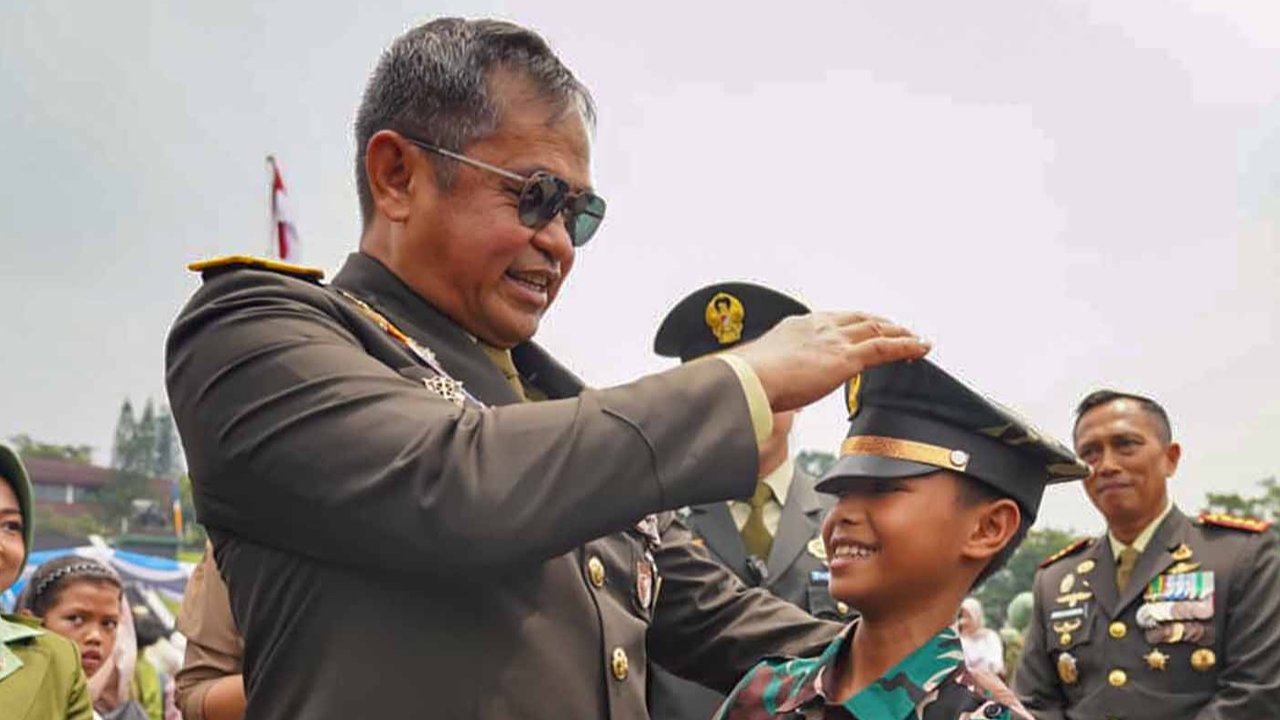 Kepala Staf Angkatan Darat (Kasad) Jenderal TNI Maruli Simanjuntak mengenakan topi berpuncak miliknya kepada seorang anak  anak saat pelantikan  1.268 Perwira Remaja TNI Angkatan Darat di Lapangan Krida Wiradhika, Secapaad Bandung, Selasa (21/10/2025).
