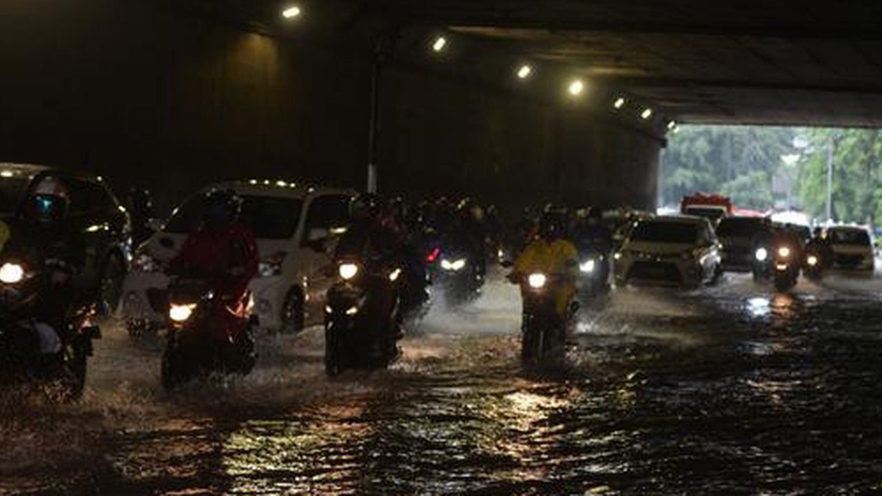Pengendara sepeda motor menerjang banjir yang merendam terowongan di Cawang, Jakarta, Jumat (19/2/2021). Hujan yang turun sejak semalam membuat sejumlah jalanan di Ibu Kota tergenang banjir d
