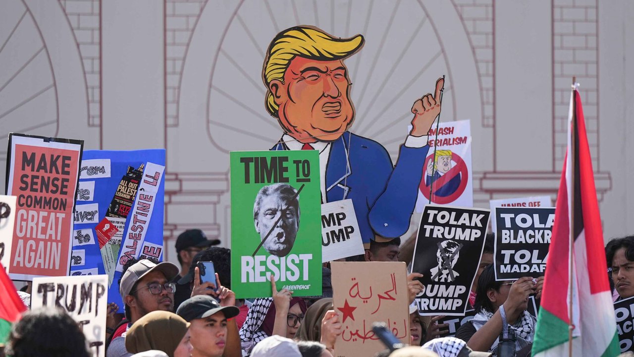 Para demonstran memegang spanduk saat demonstrasi menentang kehadiran Presiden AS Donald Trump di KTT ASEAN di Kuala Lumpur, Malaysia, Minggu (26/20/2025).