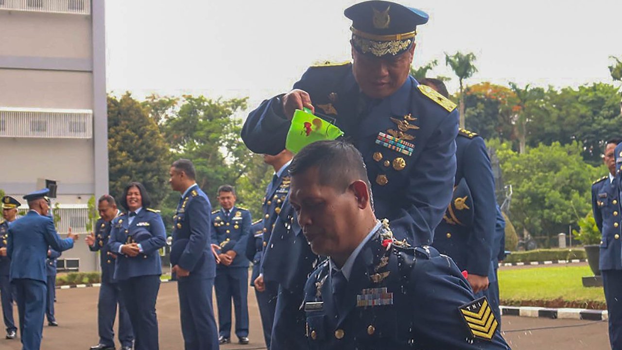 Personel Koops Udara Nasional TNI AU basah kuyup saat dimandikan usai  upacara kenaikan pangkat di Makoopsudnas, Jakarta, Rabu (1/10/2025).