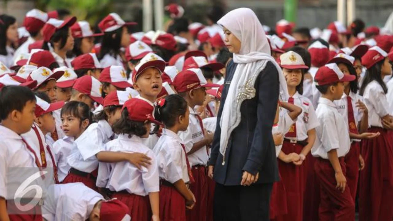 Guru mengatur para murid sebelum upacara di SD Pasar Baru 05, Jakarta, Senin (27/7/2015). Usai libur panjang Idul Fitri para siswa kembali beraktivitas mengikuti pelajaran di sekolah untuk ta