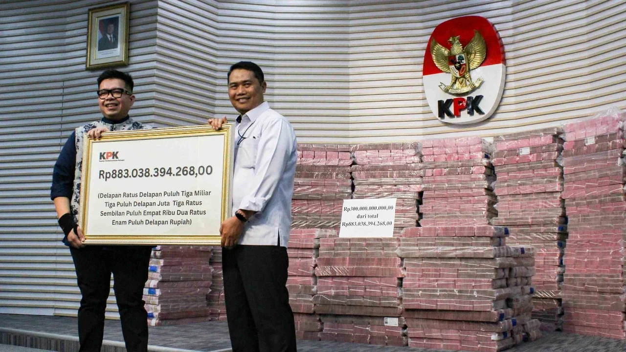 Petugas mengangkut uang dari tumpukan sebesar Rp 300 miliar yang dipamerkan di
gedung Merah Putih Komisi Pemberantasan Korupsi (KPK), Jakarta, Kamis (20/11/2025).