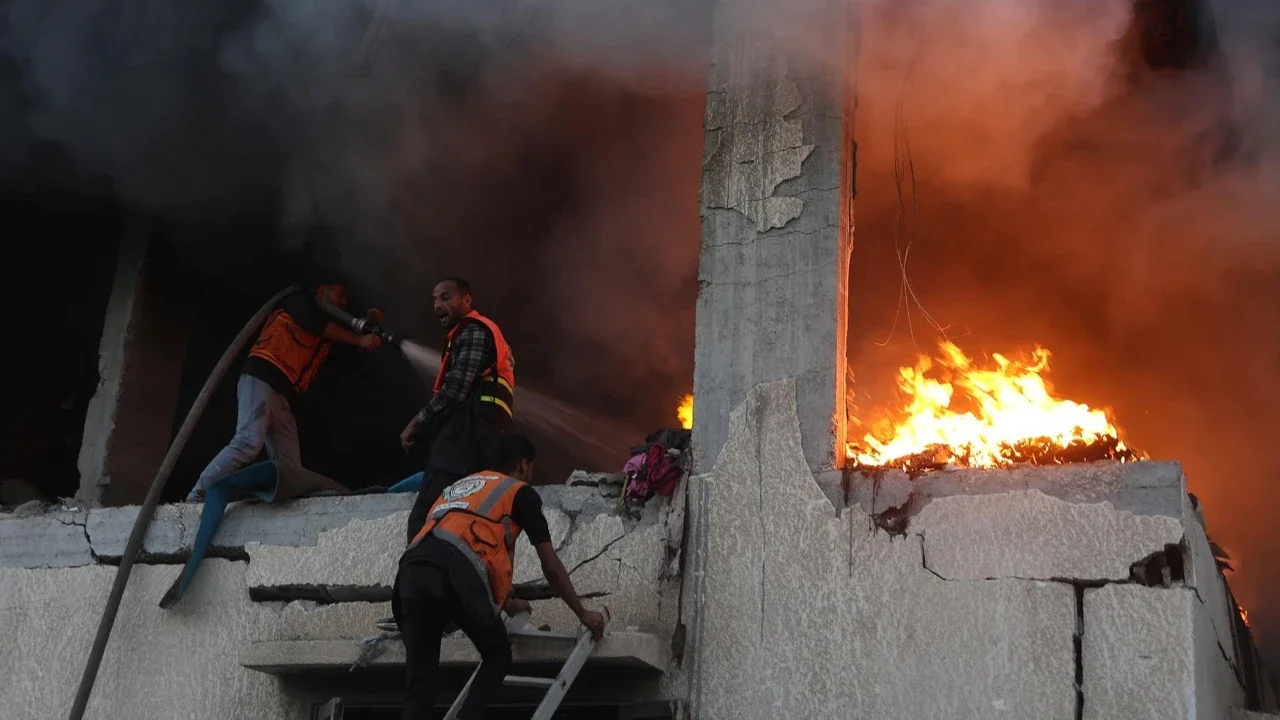 Personel pertahanan sipil memadamkan api rumah yang terbakar akibat serangan udara Israel di Kota Gaza, Sabtu (22/11/2025).