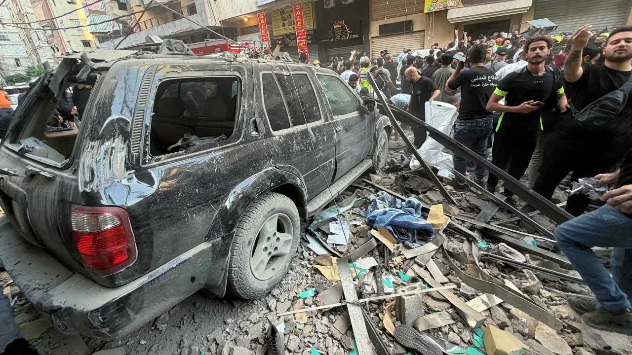 Warga berkerumun di lokasi serangan udara Israel yang menargetkan sebuah bangunan perumahan dan menewaskan kepala staf Hizbullah Haytham Tabtabai di kawasan Haret Hreik, Beirut, selatan, Minggu (23/11/2026).