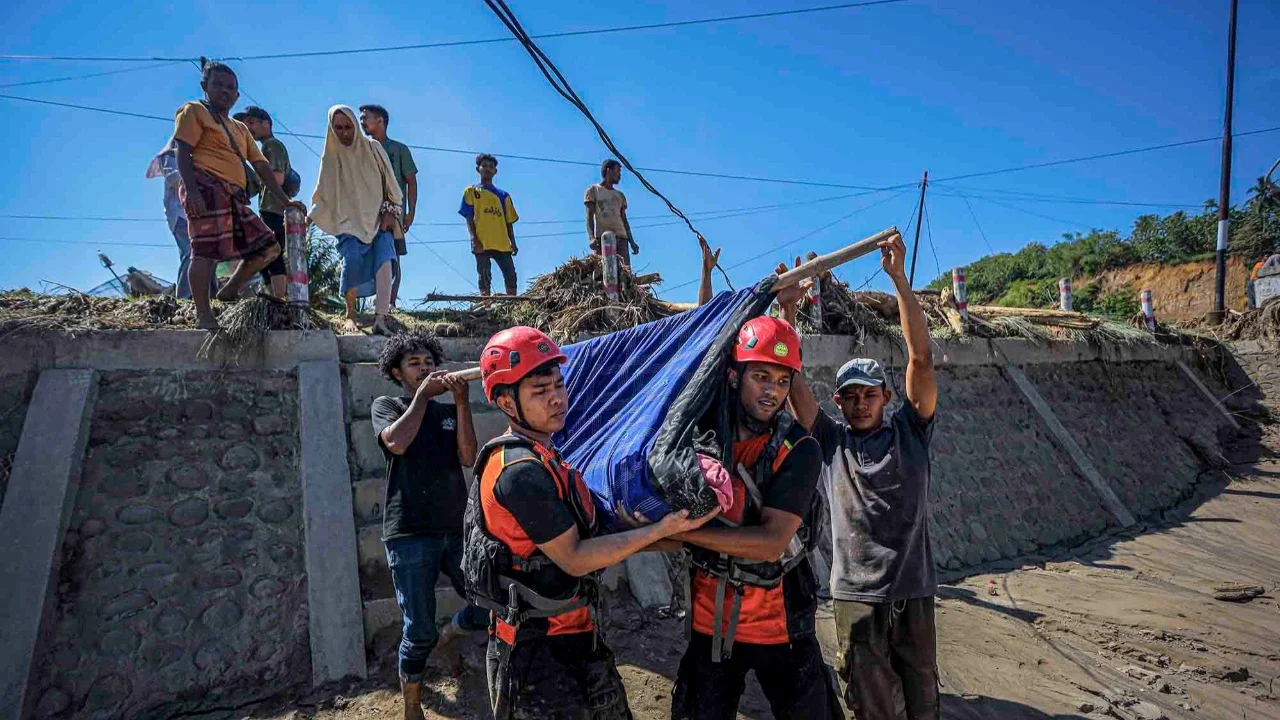 Petugas penyelamat saat mengevakuasi warga desa yang sakit untuk dibawa ke rumah sakit terdekat di Bireuen, Provinsi Aceh, Sabtu (29/11/2025).