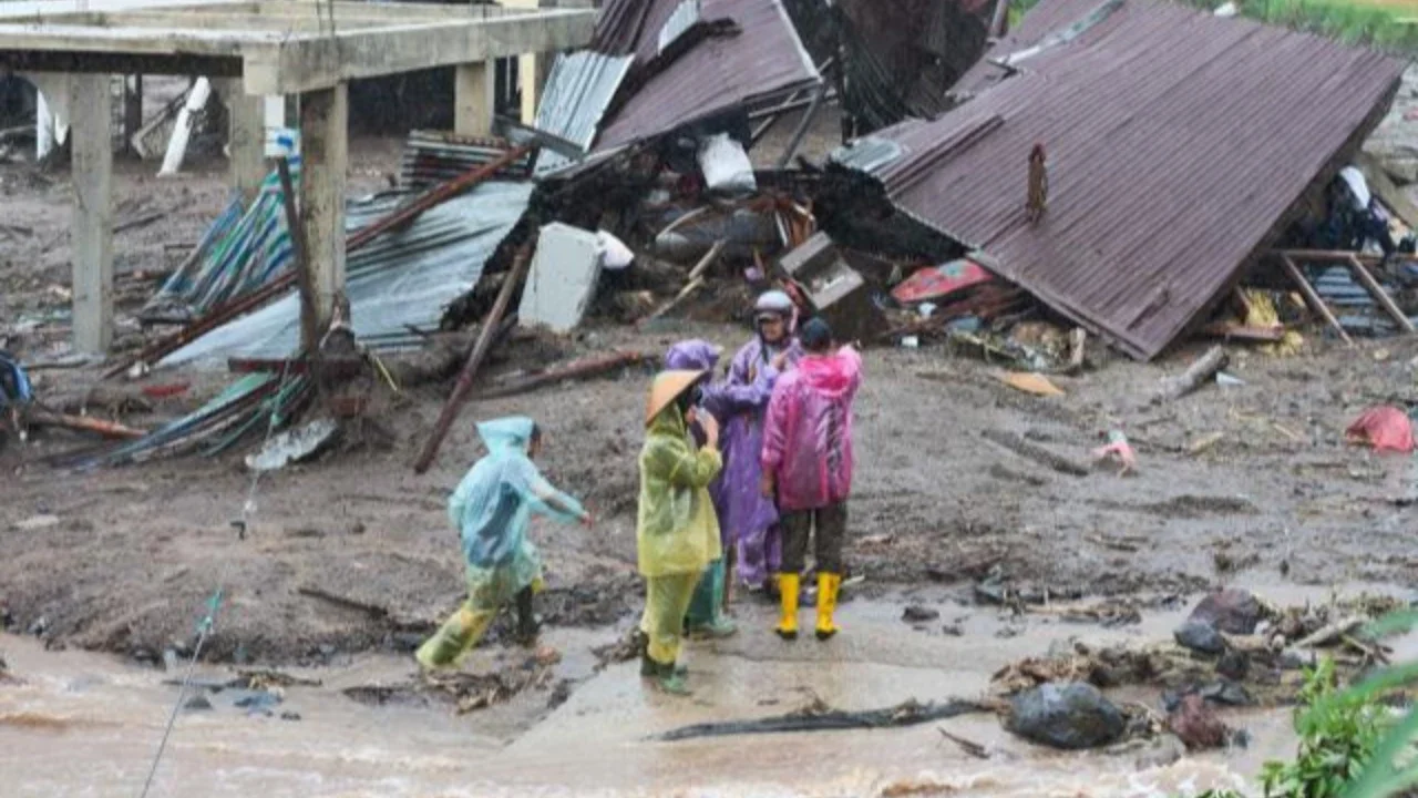 Warga berjalan melewati rumah-rumah yang rusak di sebuah desa yang terdampak banjir di Malalak, Sumatera Barat, Jumat 28 November 2025. Jelang akhir November 2025, bencana banjir bandang dan