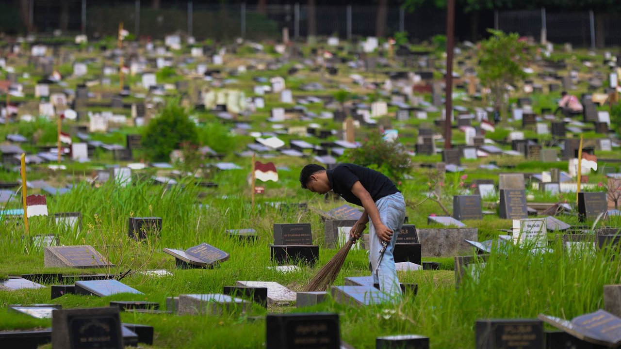Petugas Suku Dinas Pertamanan dan Hutan Jakarta Selatan merawat makam di Tempat Pemakaman Umum (TPU) Tanah Kusir, Rabu (5/11/2025).