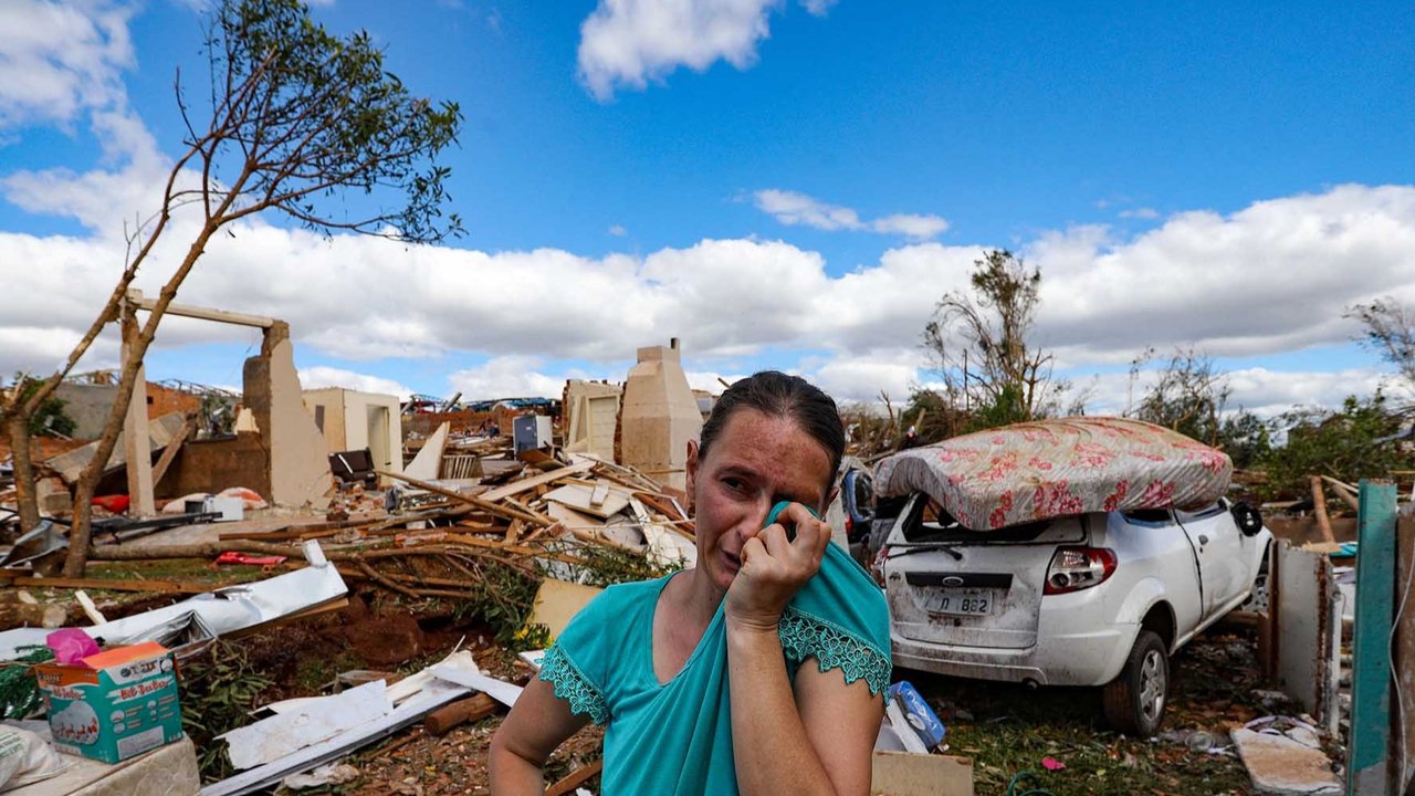 Warga menangis berdiri di atas rumahnya yang hancur  akibat tornado dengan kecepatan angin hingga 250 km/jam yang melanda kota Rio Bonito do Iguacu, di negara bagian Parana, Brasil, Sabtu (08/11/2025) waktu setempat.