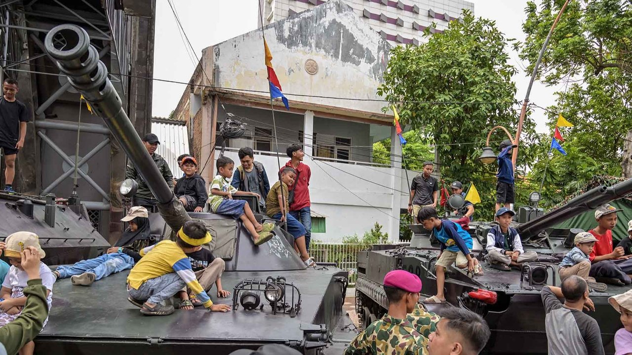Warga menaiki kendaraan militer selama Pekan Raya Marinir Indonesia di Jalan Gubernur Suryo, Surabaya, Jawa Timur, Minggu (9/11/2025).