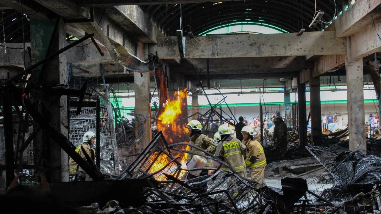 Petugas pemadam kebakaran saat memadamkan api pada lapak buah di Pasar Induk Kramat Jati, Jakarta Timur, Senin (15/12/2025).