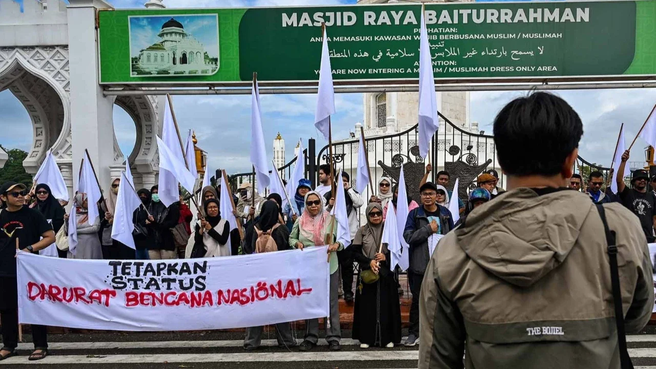 Massa dari berbagai elemen yang tergaabung dalam Aksi Koalisi Masyarakat Sipil Aceh melakukan aksi unjuk rasa di depan Masjid Raya Baiturrahman, Banda Aceh, Kamis (18/12/2025).