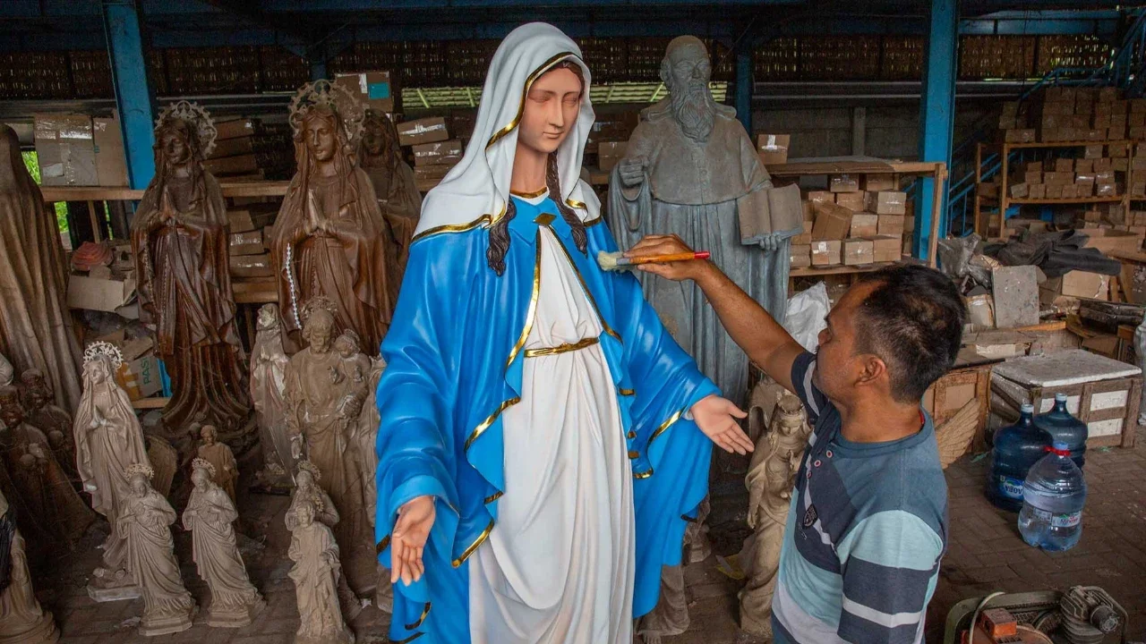 Seorang pekerja menyelesaikan pembuatan patung keagamaan Kristen di bengkel kerajinan Studio Malta Jaya di Bantul, Yogyakarta, Kamis (18/12/2025).