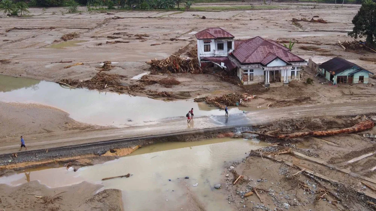 Warga memeriksa pakaian yang mereka selamatkan di sebuah desa yang terdampak banjir bandang di Batang Toru, Sumatera Utara, Indonesia, Selasa (02/12/2025).