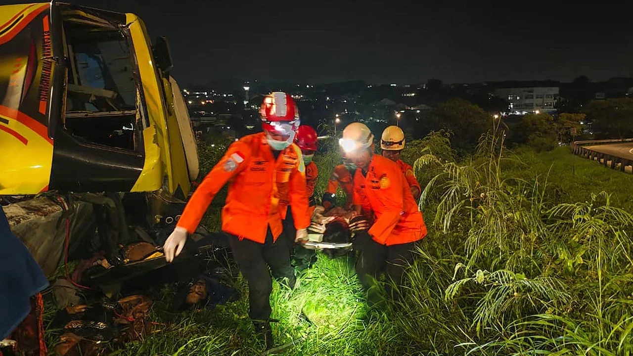 Petugas Basarnas mengevakuasi penumpang meninggal usai kecelakaan bus PO Cahaya Trans di ruas simpang susun exit tol Krapyak Kota Semarang, Senin (22/12/2025).