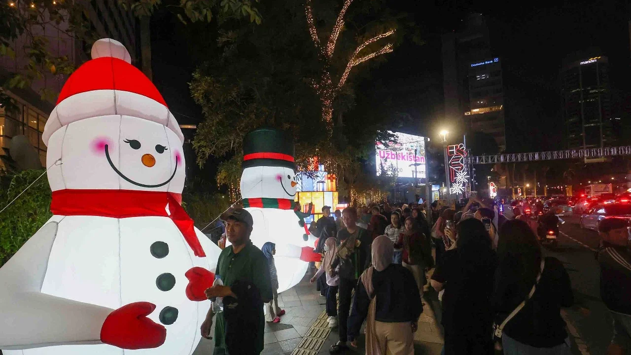 Warga menikmati suasana Jakarta Light Festival 2025 di sekitar Bundaran Hotel Indonesia, Jakarta, Selasa (23/12/2025).