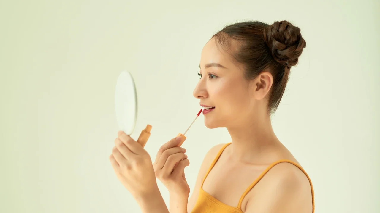 Ilustrasi perempuan menggunakan lip tint.