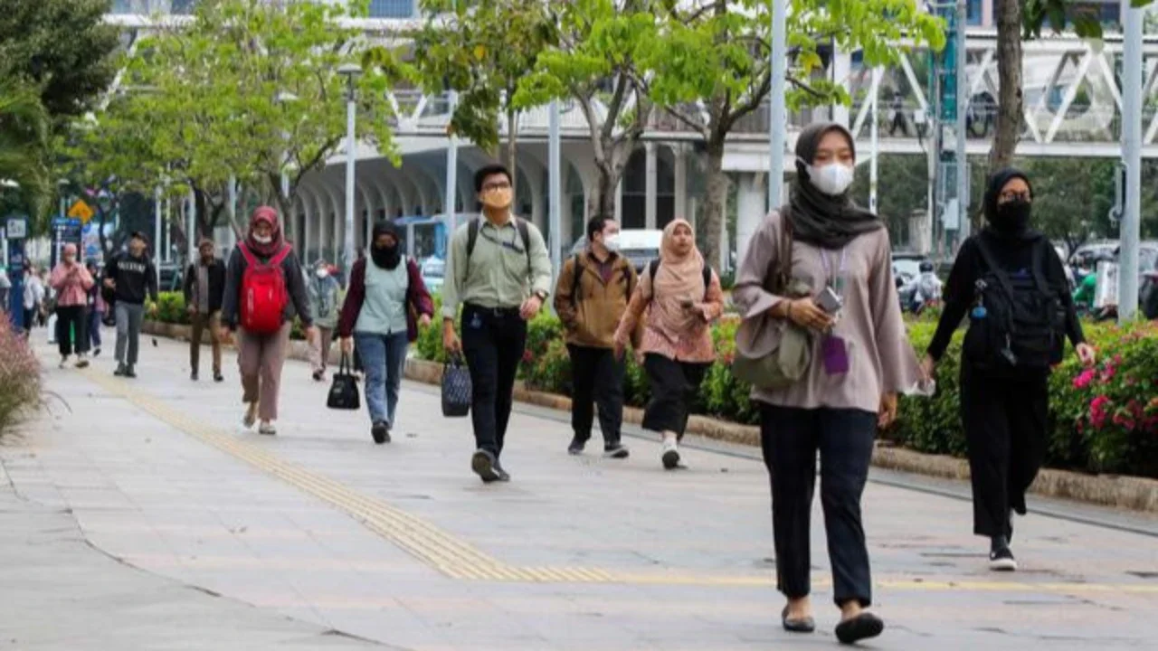 Pekerja tengah melintas di kawasan Kendal, Jakarta, Jumat (9/12/2022). Pemerintah Provinsi DKI Jakarta resmi menaikkan upah minimum provinsi (UMP) 2023 sebesar 5,6 persen atau menjadi Rp 4,9