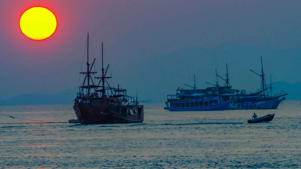 Perahu melintasi matahari terbenam di Labuan Bajo, NTT