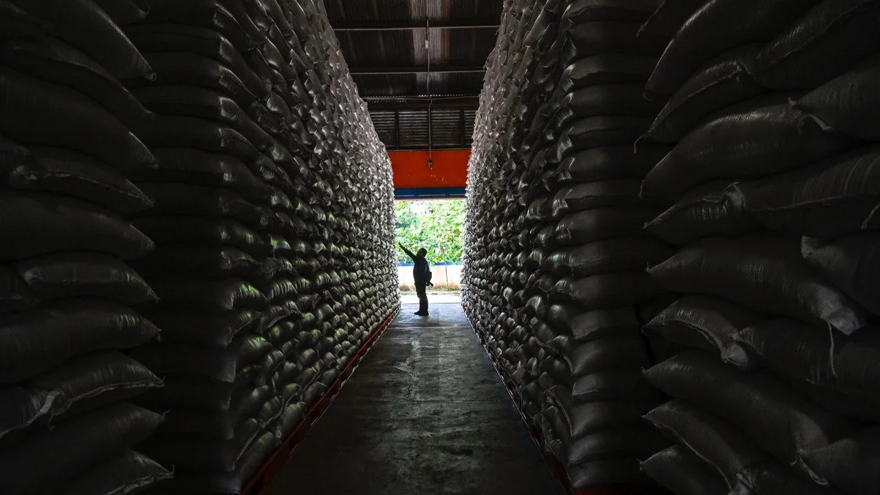 Pekerja memeriksa tumpukan beras di gudang Badan Logistik Indonesia (Bulog) di Lambaro, Provinsi Aceh, Senin (29/12/2025).