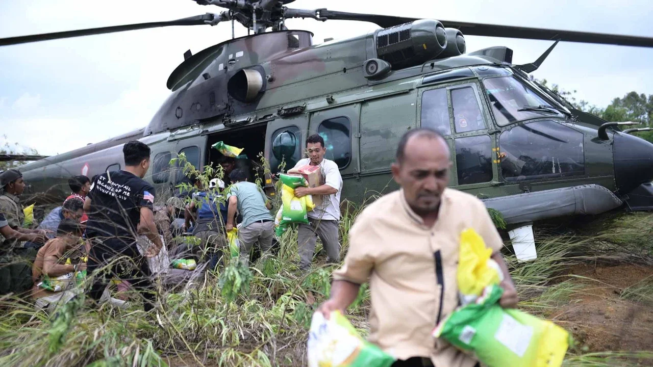 Warga saat mendapatkan  bantuan kemanusiaan di daerah terdampak banjir di Aceh Tengah, Indonesia, Sabtu (06/12/2025).