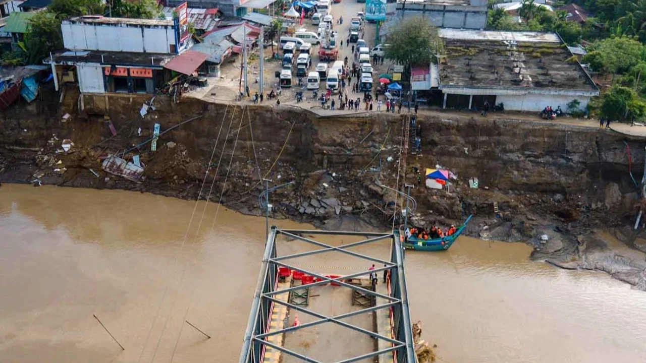 Warga menyeberangi Sungai Peusangan dengan perahu nelayan di Kuta Blang, Kabupaten Bireuen, Provinsi Aceh, Selasa (09/12/2025).