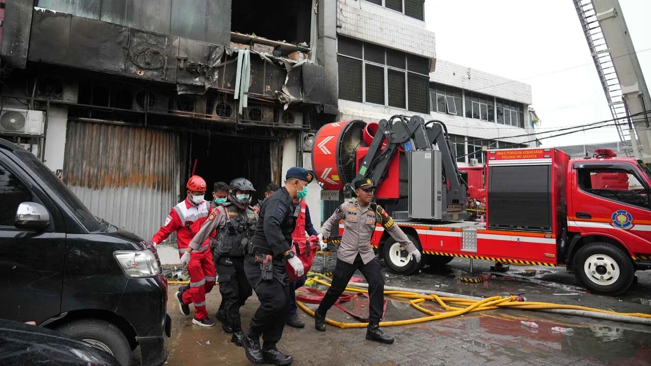 Polisi dan petugas medis mengevakuasi jenasah korban kebakaran kebakaran di gedung perkantoran Terra Drone di Jalan Letjen Suprapto, Cempaka Baru, Kemayoran, Jakarta Pusat Selasa (09/12/2025)..