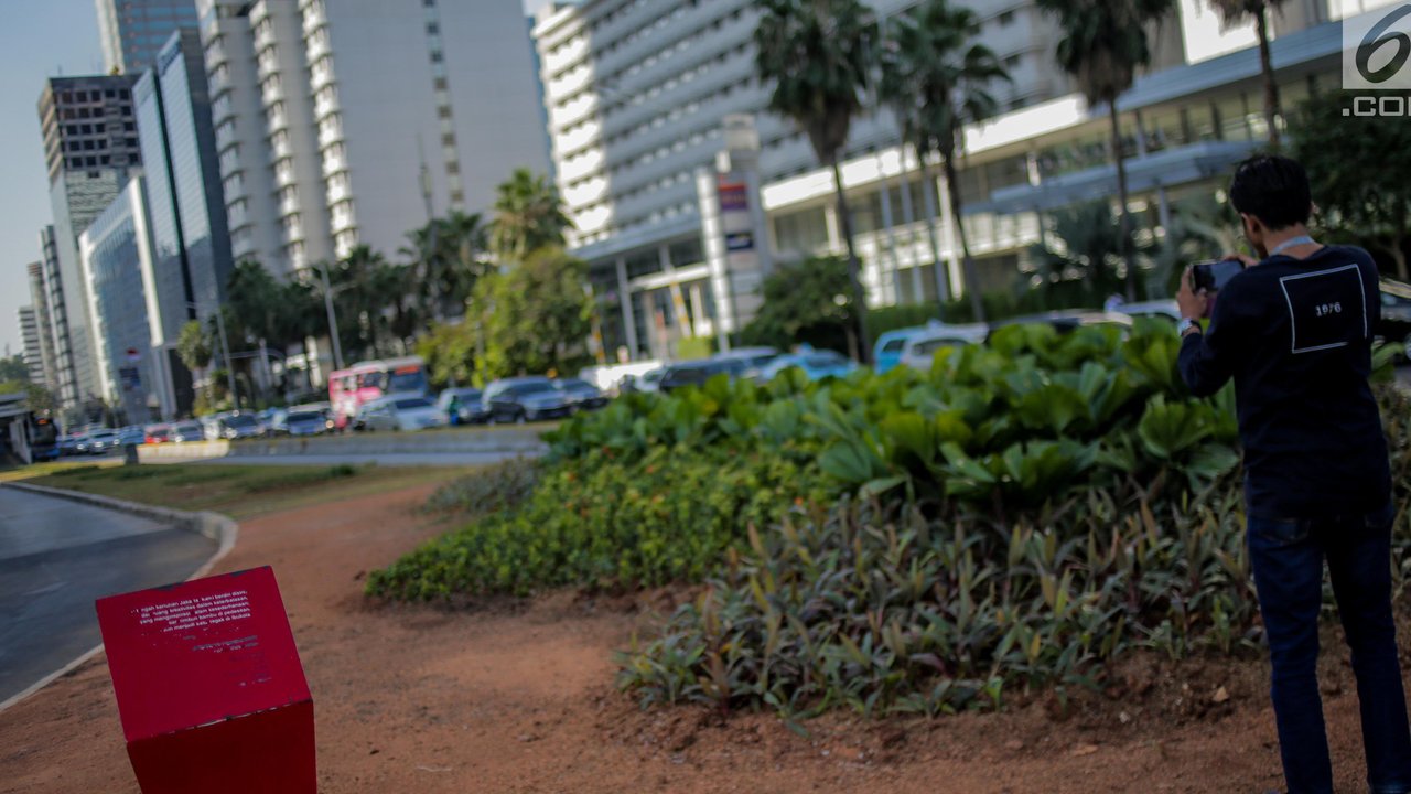 Warga mengambil gambar jalur hijau usai pembongkaran instalasi bambu Getah Getih di Bundaran HI, Jakarta, Kamis (18/7/2019). Masyarakat kini bisa melihat jelas Monumen Selamat Datang dari halte transjakarta Bundaran HI tanpa terhalang karya seni bernilai Rp550 juta itu. (Liputan6.com/Faizal Fanani)