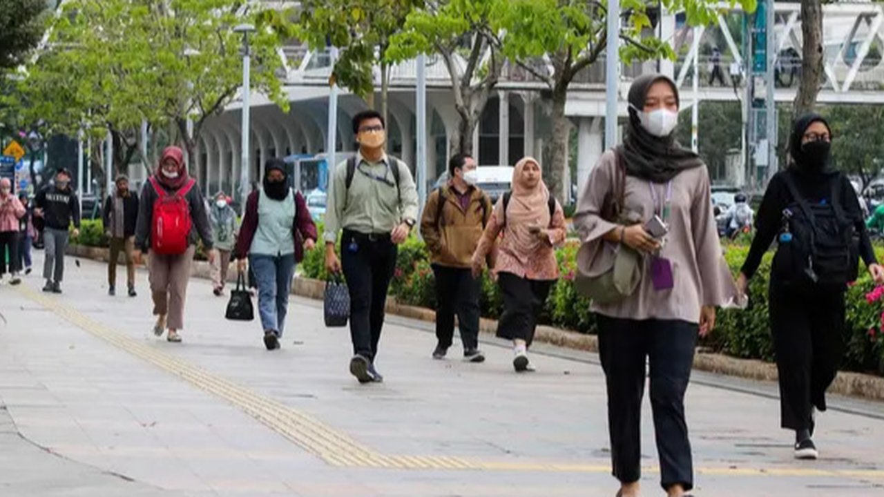 Karyawan perkantoran berjalan kaki  bergegas pulang di Kawasan Sudirman, Jakarta, Rabu (30/11/2022). Keputusan Pemerintah Provinsi (Pemprov) DKI Jakarta menaikan upah minimum provinsi (UMP) D