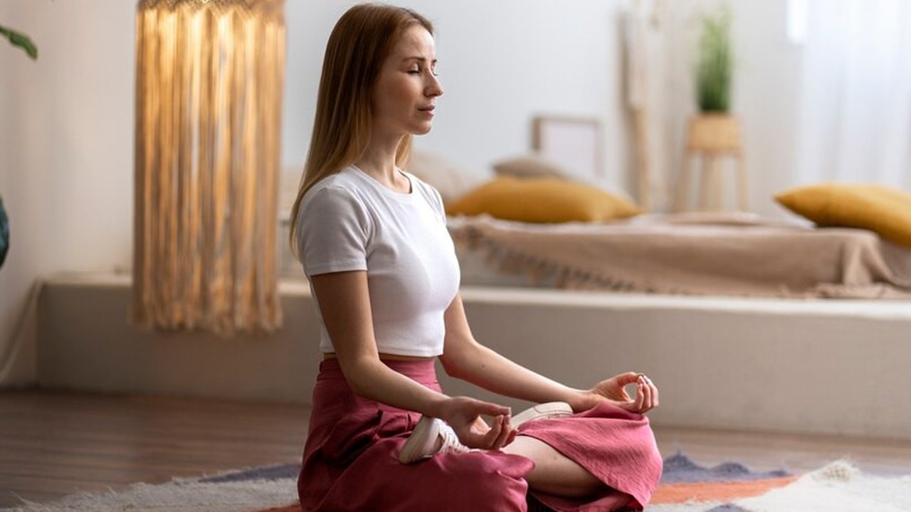Seorang perempuan melakukan meditasi secara mandiri di rumah (Foto Dok: Freepik/freepik).
