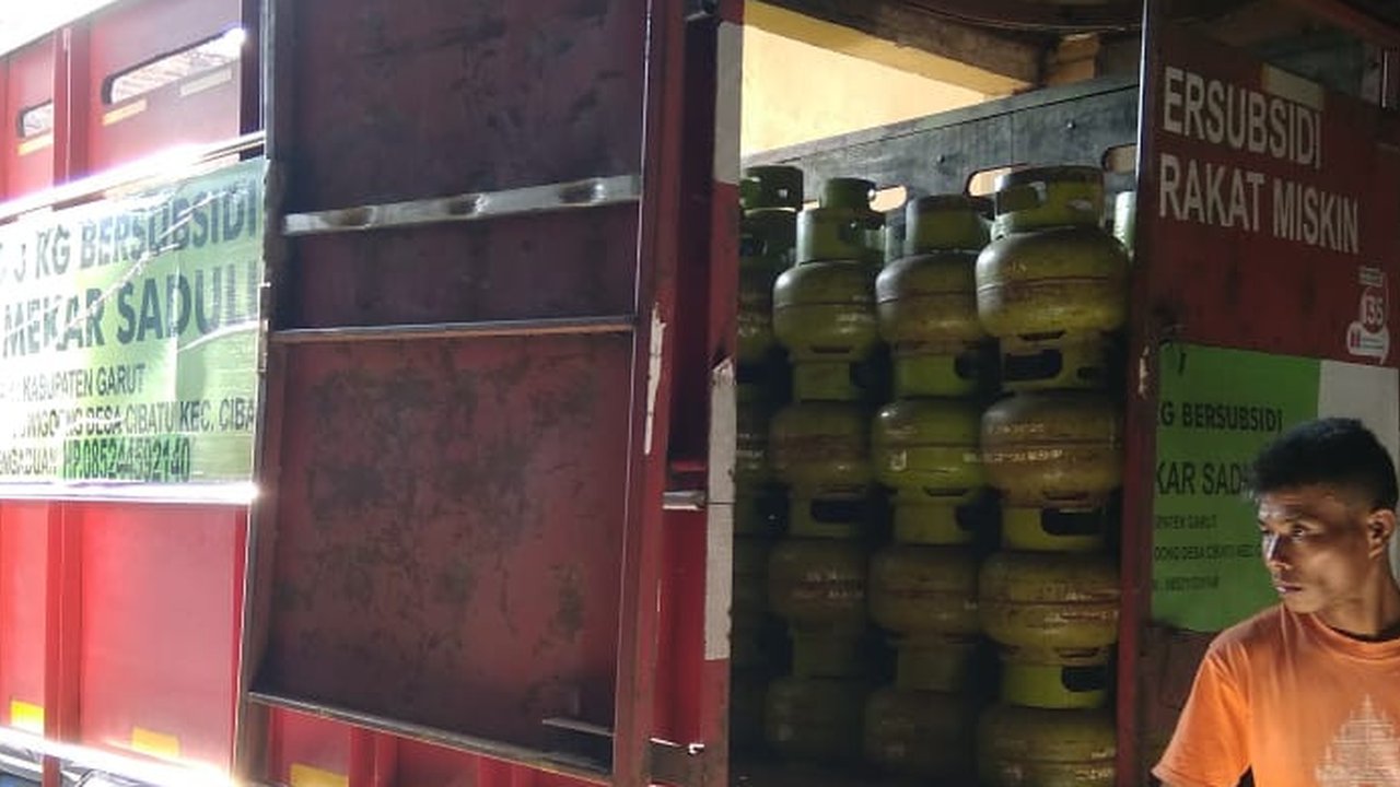 Salah seorang pegawai agen gas LPG 3 kg tengah menaikan gas melon ke salah satu mobil angkutan gas bersubisi di Garut, Jawa Barat. (Liputan6.com/Jayadi Supriadin)