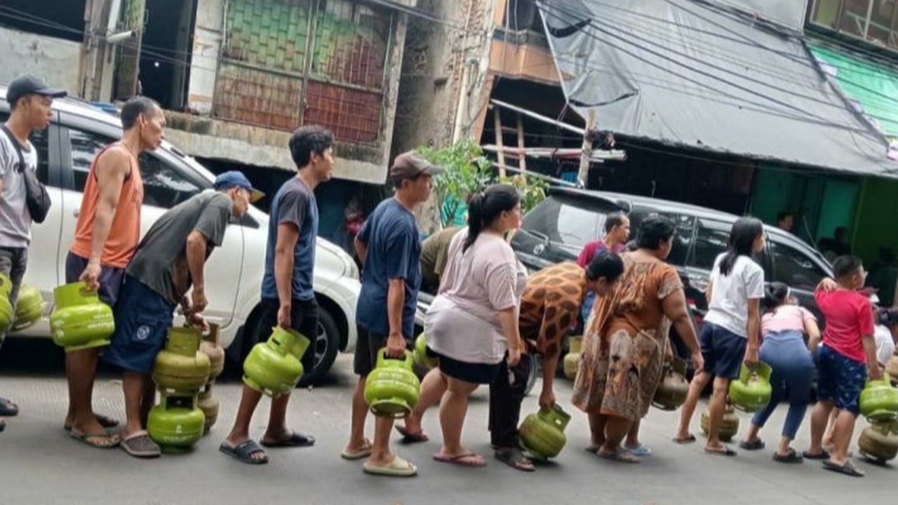 Salah seorang pegawai agen gas LPG 3 kg tengah menaikan gas melon ke salah satu mobil angkutan gas bersubisi di Garut, Jawa Barat. (Liputan6.com/Jayadi Supriadin)