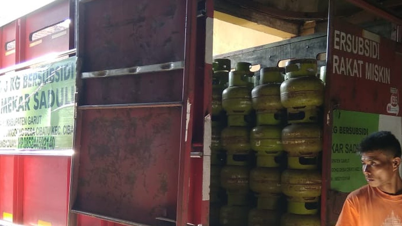 Salah seorang pegawai agen gas LPG 3 kg tengah menaikan gas melon ke salah satu mobil angkutan gas bersubisi di Garut, Jawa Barat. (Liputan6.com/Jayadi Supriadin)
