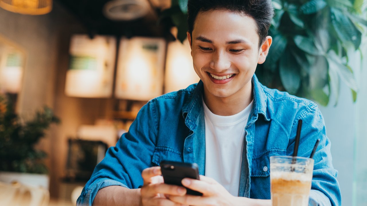 Seorang pria memakai ponsel.