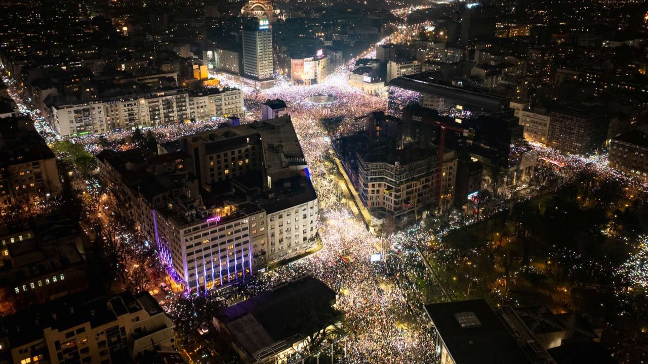 Ribuan pengunjuk rasa menyalakan flashlight pada telepon genggam mereka untuk menerangi langit malam saat mengenang korban tragedi Novi Sad dalam aksi demo antikorupsi terbesar di Beograd, Serbia, pada 15 Maret 2025.