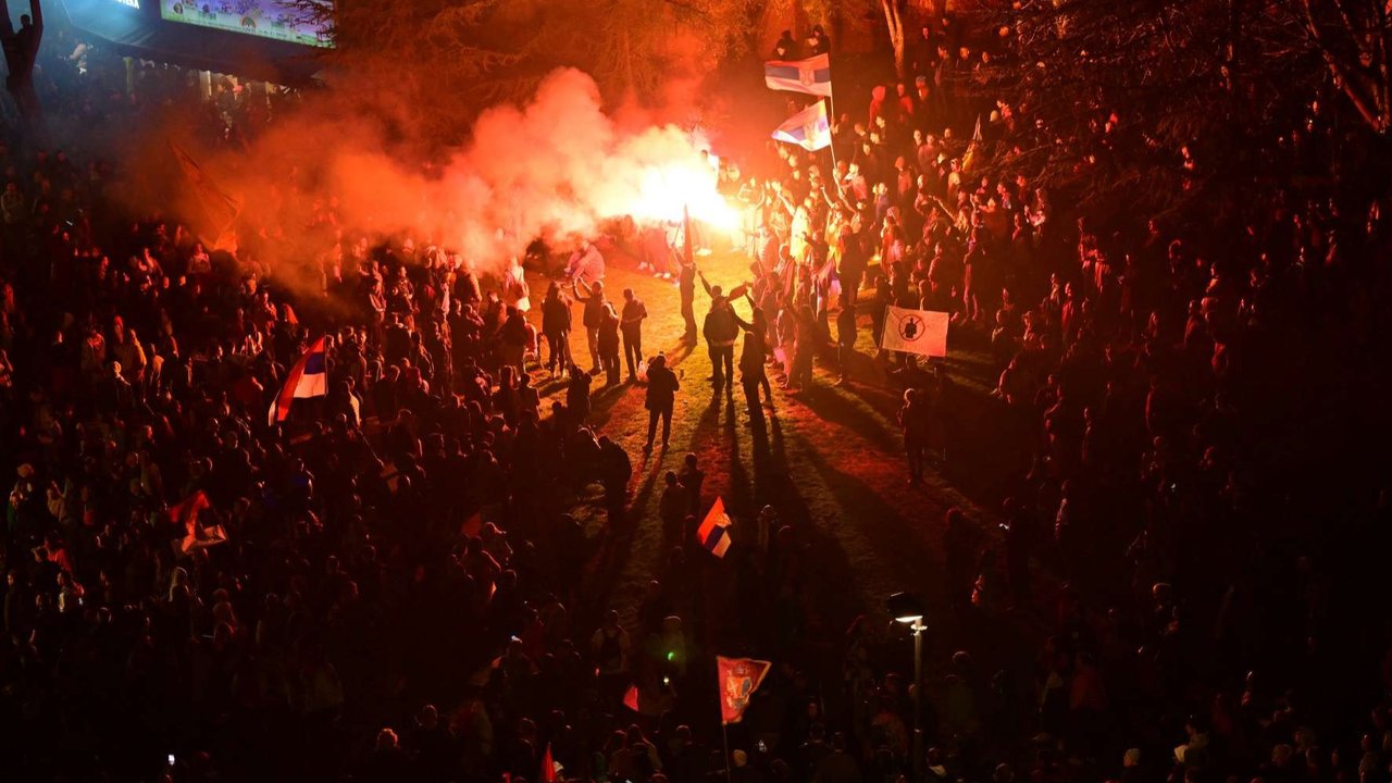 Ribuan pengunjuk rasa menyalakan flashlight pada telepon genggam mereka untuk menerangi langit malam saat mengenang korban tragedi Novi Sad dalam aksi demo antikorupsi terbesar di Beograd, Serbia, pada 15 Maret 2025.