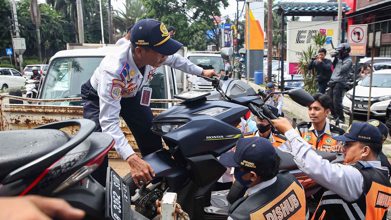 Petugas Suku Dinas Perhubungan Jakarta Selatan menertibkan puluhan kendaraan bermotor roda dua yang melakukan parkir liar di sepanjang kawasan Gandaria City hingga Pondok Indah, Jakarta Selatan, Selasa (18/3/2025).