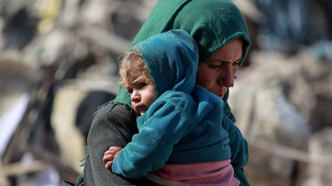 Seorang wanita Palestina menggendong bayi di wilayah timur Gaza,  Palestina, Selasa (18/03/2025).