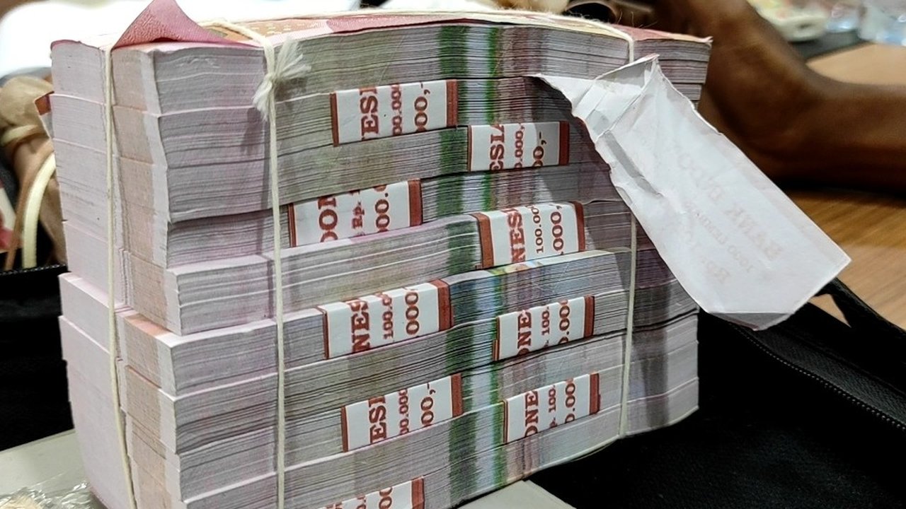 Petugas merapikan uang palsu saat rilis pengungkap penyebaran uang palsu di Gedung Lobby Bareskrime Mabes Polri, Jakarta, Kamis (23/9/2021). Bareskrim Polri mengungkap kasus tindak pidana pem
