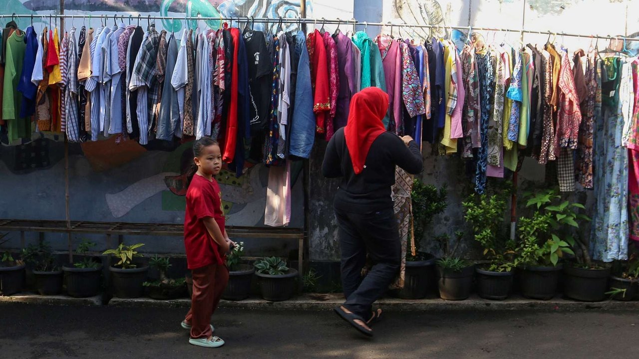 Warga memilih sayur dan pakaian saat mengunjungi bazar makanan dan pakaian layak pakai gratis di Jalan Jati Padang VI, Pasar Minggu, Jakarta, Jumat (21/3/2025).