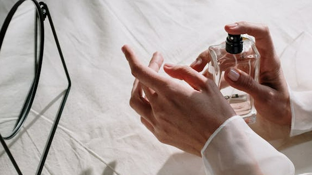 Seseorang yang sedang Menyemprotkan Parfum di Tangannya