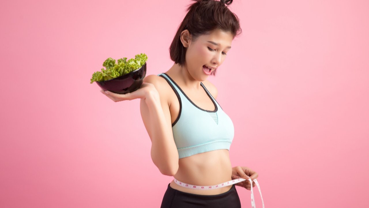 Wanita yang Mengukur Badannya dan Membawa Makanan Dietnya