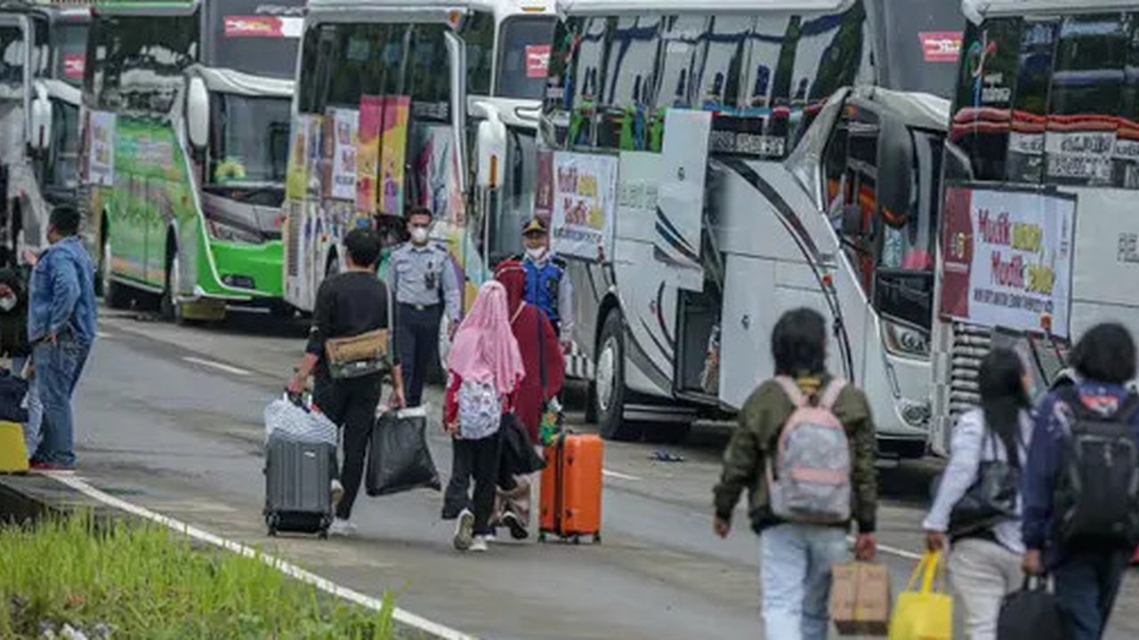 Peserta Mudik Aman Mudik Sehat Kementerian Perhubungan membawa barang bawaan mereka berjalan menuju bus tujuan kampung halamannya di Terminal Jatijajar, Depok, Jawa Barat, Kamis (28/4/2022