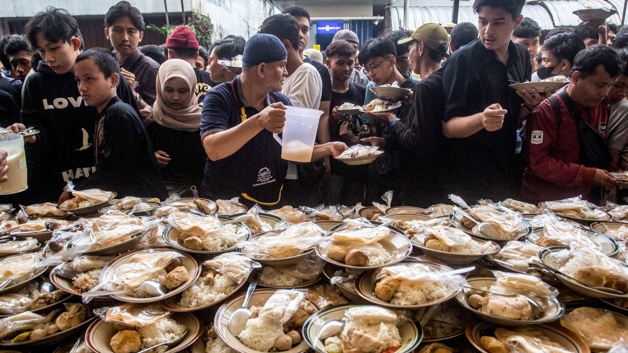 Umat muslim menerima makanan gratis untuk berbuka puasa selama Ramadan di Masjid Jogokariyan di Yogyakarta, pada 2 Maret 2025.