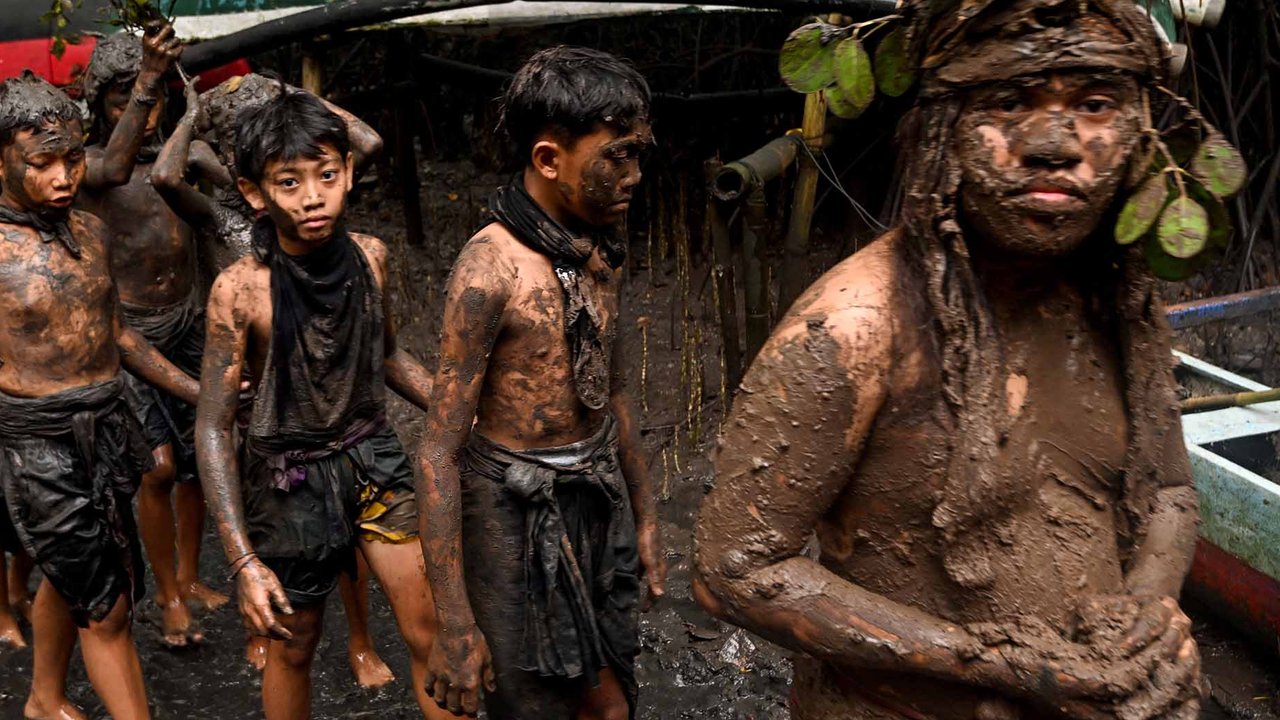 Warga adat Desa Kedonganan saa mengikuti t kegiatan tradisi mandi lumpur di Desa Kedonganan, Badung, Bali, Minggu (30/03/2025).