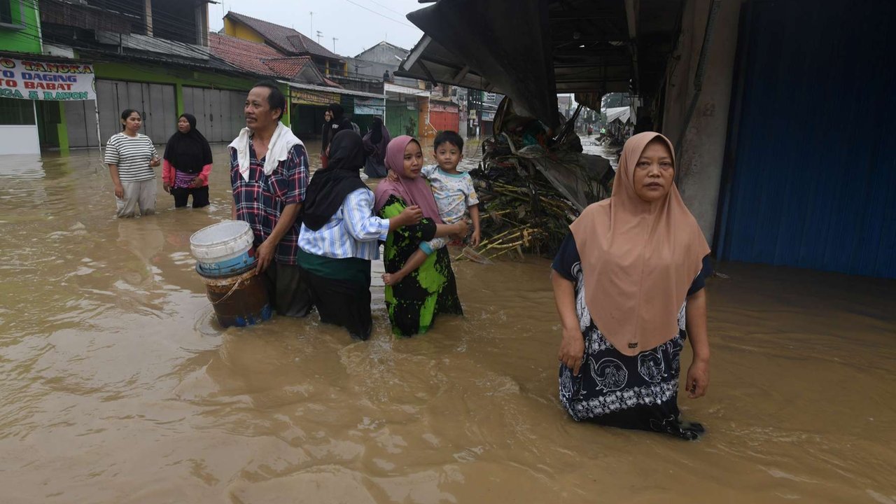Warga berjalan di tengah banjir yang merendam Perumahan Vila Nusa Indah 3, Bojong Kulur, Gunung Putri, Kabupaten Bogor, Selasa (4/3/2025).