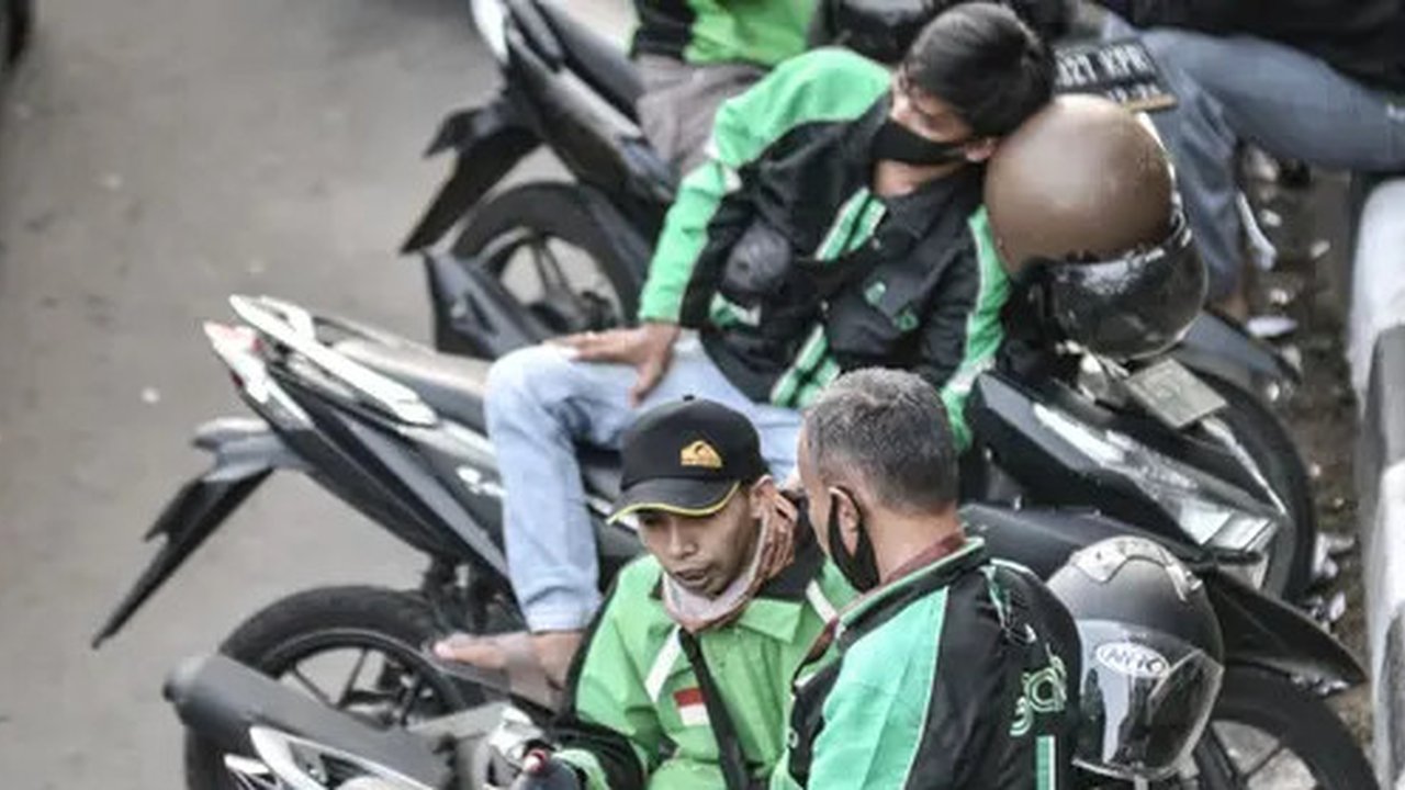 Pengemudi ojek online (ojol) memenuhi bahu jalan saat menunggu penumpang di kawasan Cililitan, Jakarta, Rabu (16/9/2020). Pemprov DKI Jakarta telah melarang ojol dan ojek pangkalan berkumpul