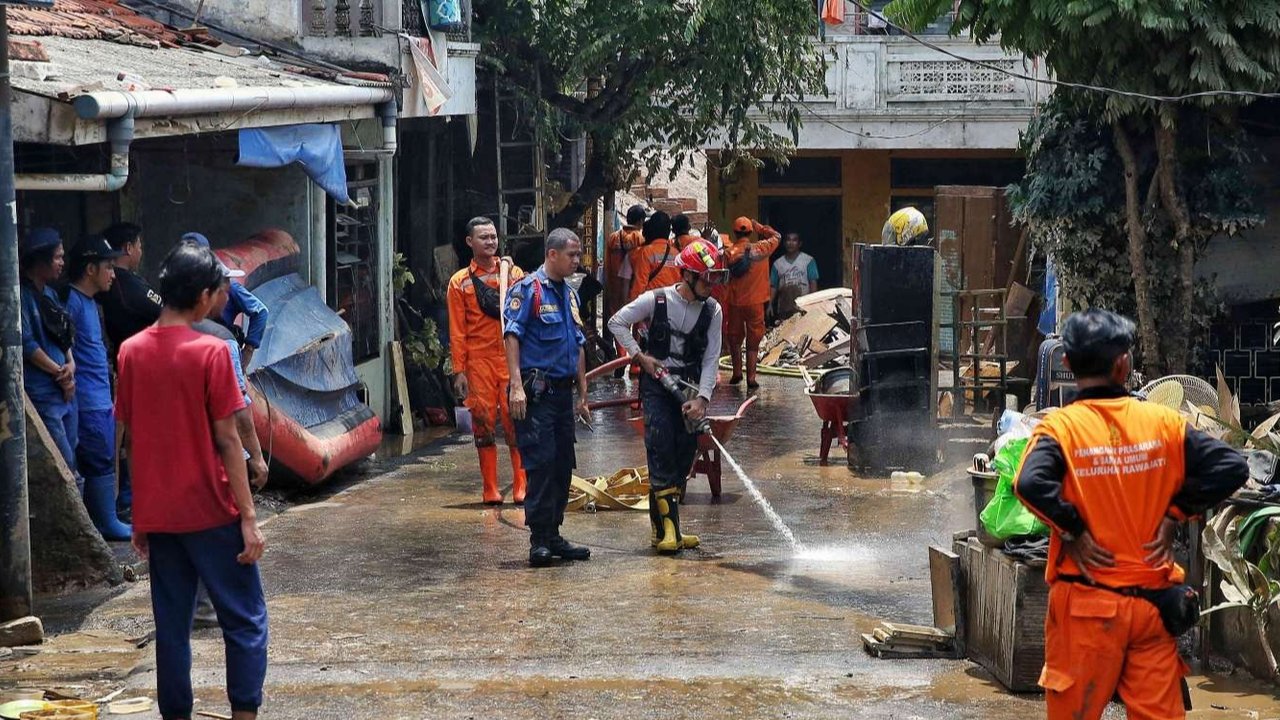 Petugas pemadam kebakaran membantu warga membersihkan lumpur setelah banjir melanda pemukiman di kawasan Kalibata, Jakarta, Rabu (5/3/2025).