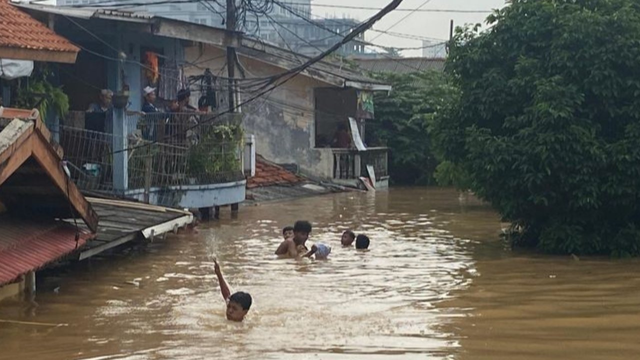 Banjir setinggi tiga meter di Rawajati, Jakarta Selatan, tak menyurutkan sejumlah anak untuk berenang, menciptakan pemandangan yang memprihatinkan sekaligus mengundang pertanyaan tentang keselamatan mereka.